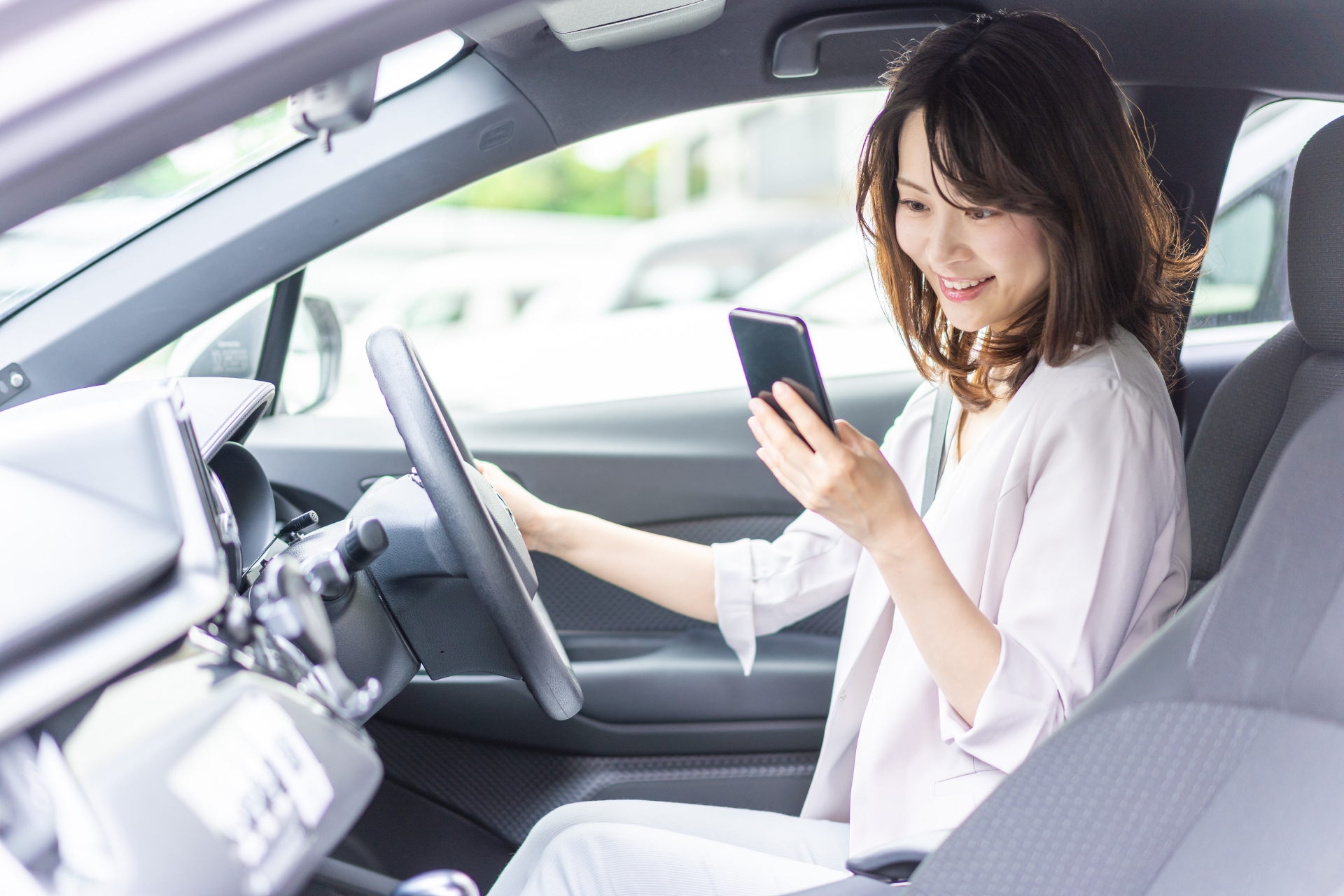 車の運転席でスマホを確認する人
